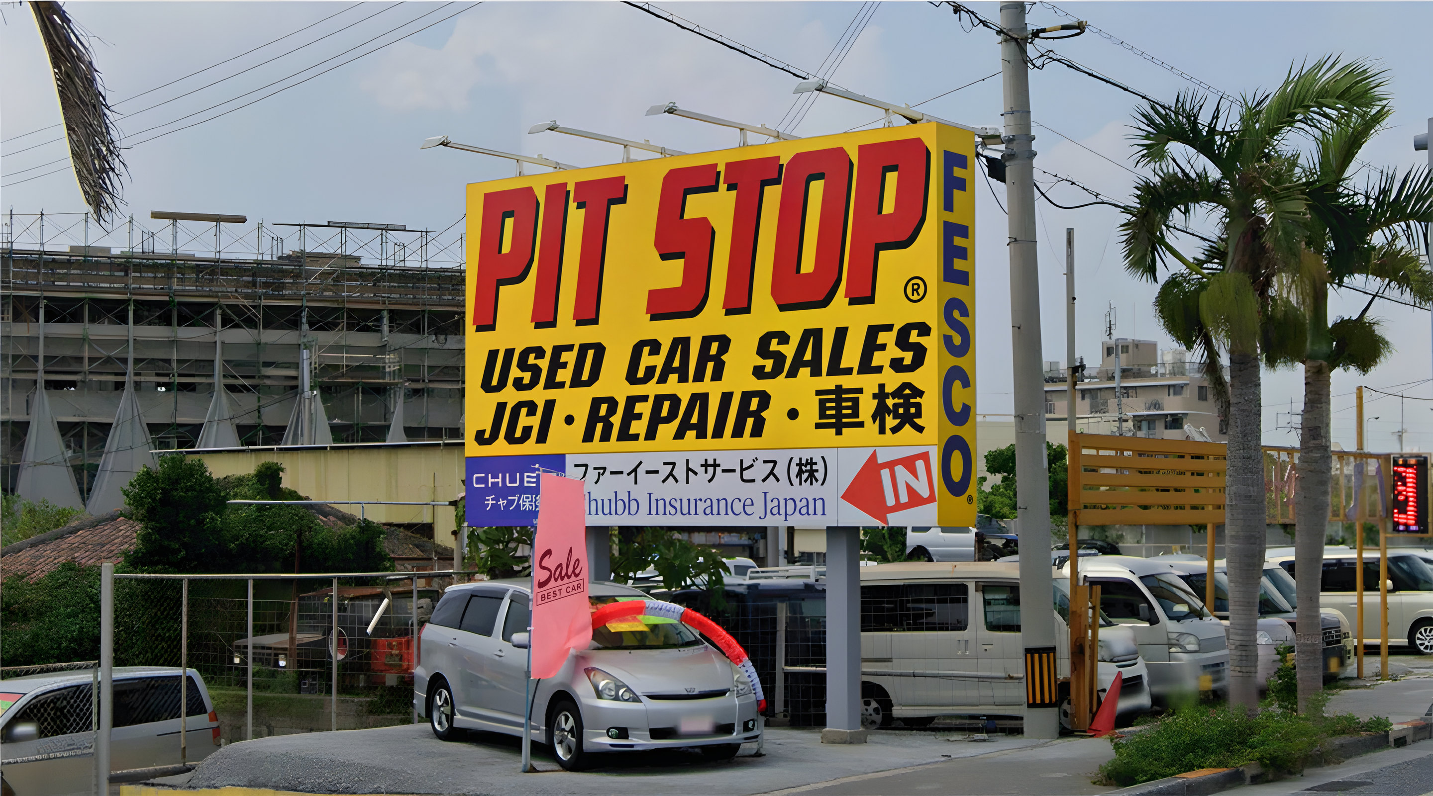 The PIT STOP pole sign in Isa as seen from the road: PIT STOP Used Car Sales, JCI, Repair, with the FESCO and CHUBB panels and the IN arrow